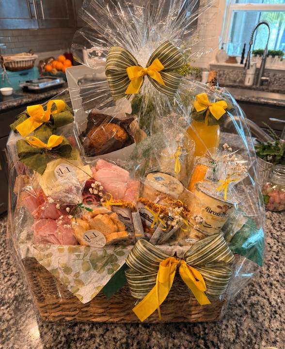 Handcrafted breakfast basket finished with transparent wrapping and yellow and green bows